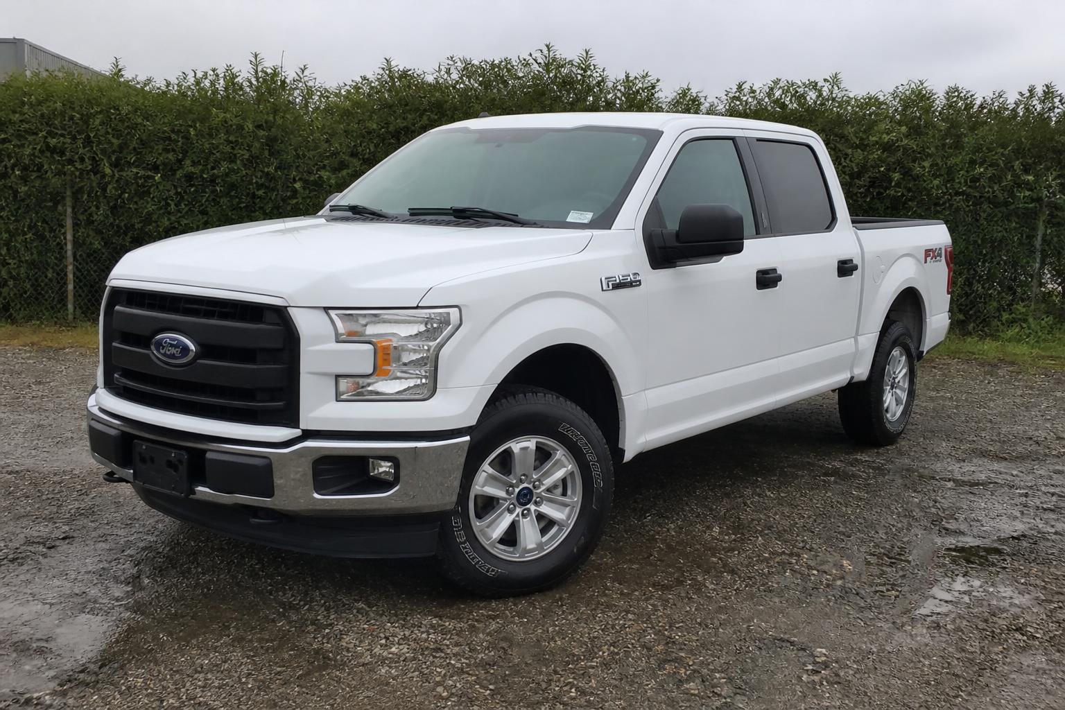 Ford F-150 pickup truck photographed on a wet gravel forecourt