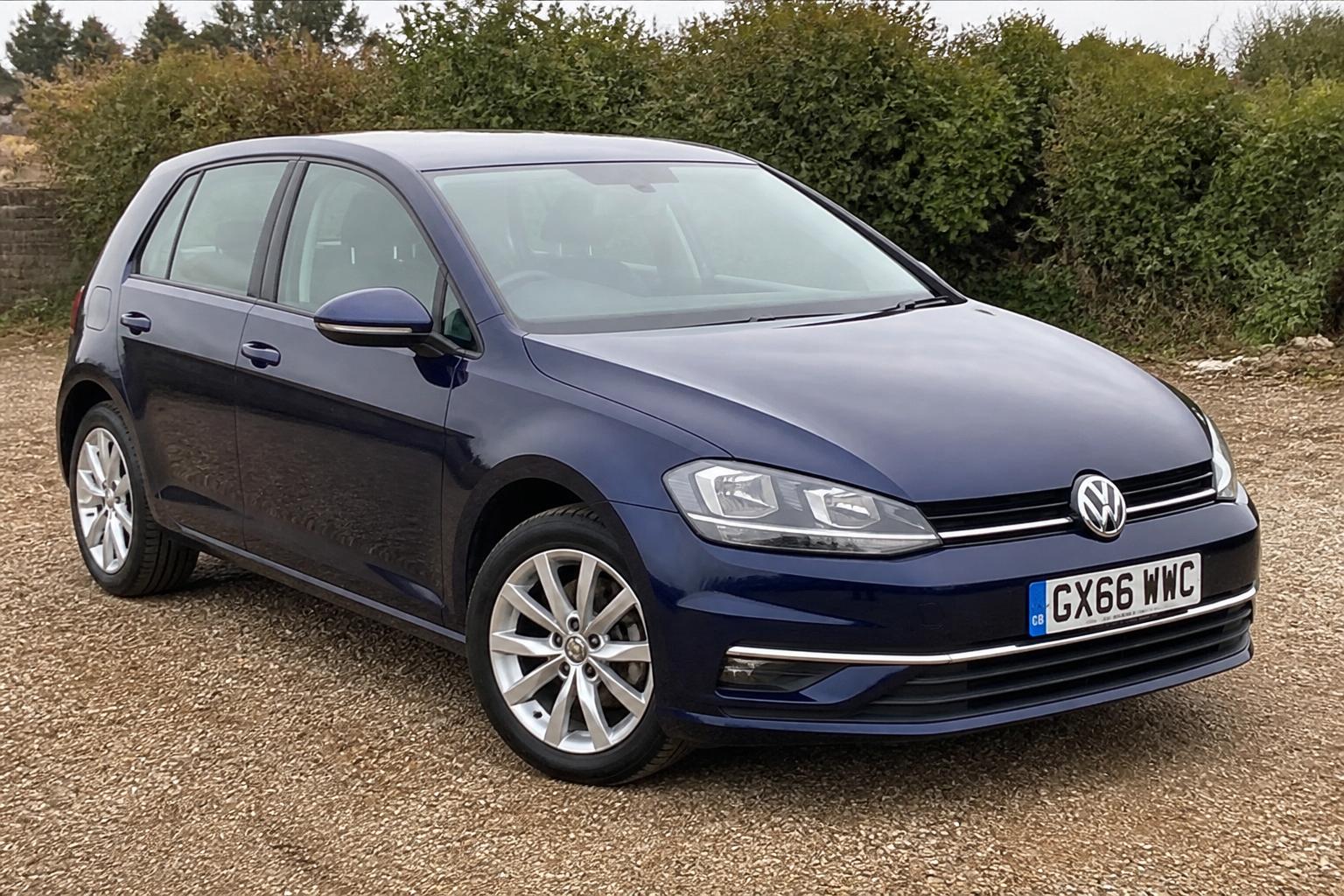 Dark blue Volkswagen Golf photographed on a gravel forecourt